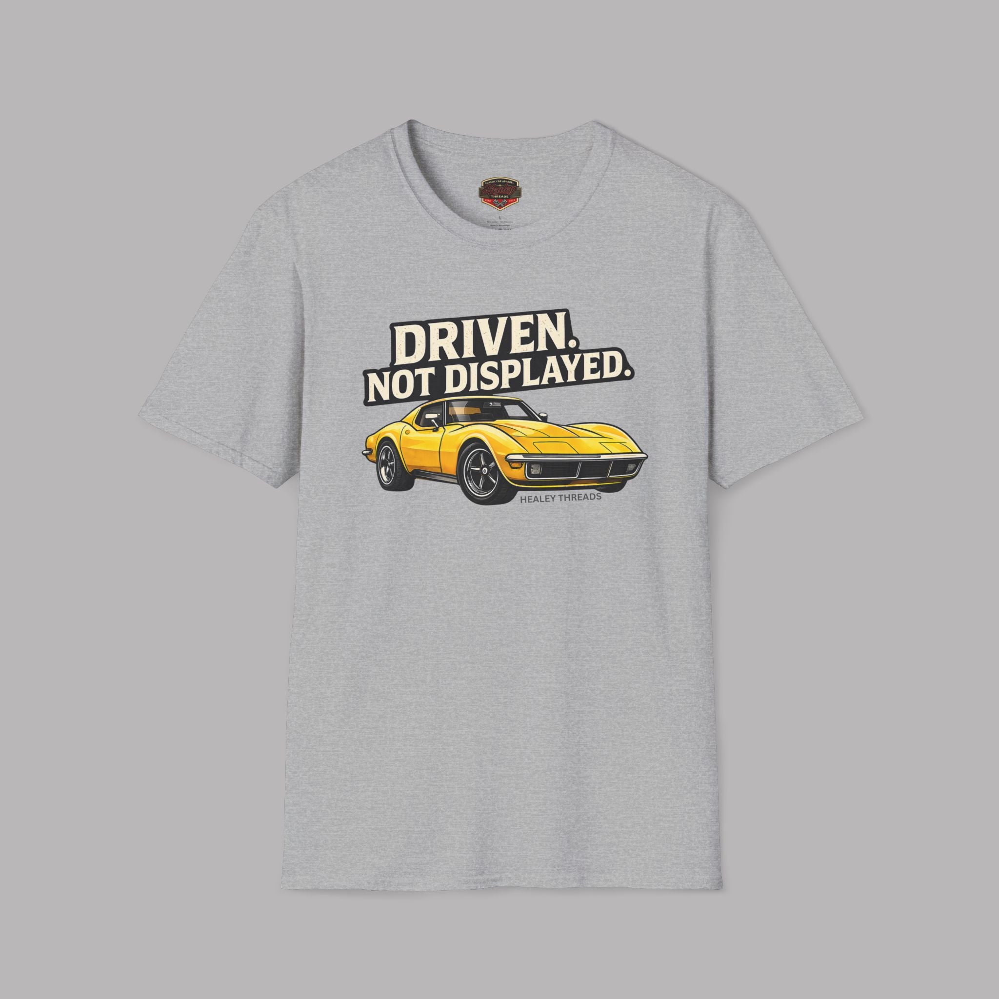 Sport gray t-shirt with a yellow muscle car graphic and text 'Driven. Not Displayed.' on a gray background