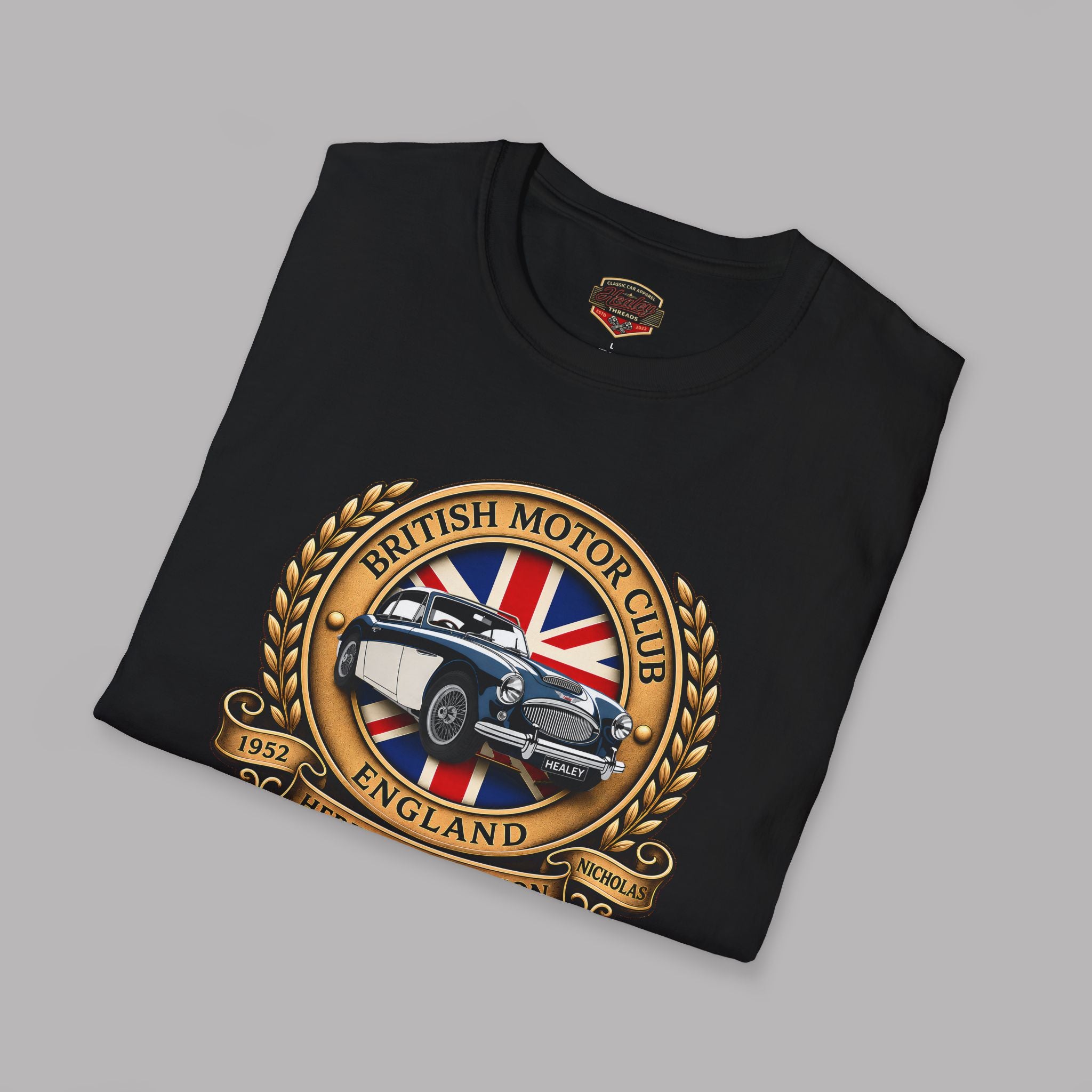 Folded black t-shirt with British Motor Club logo on a gray background