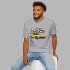 Man wearing a sport gray t-shirt with a muscle car graphic and text, sitting on a white stool against a gray background.