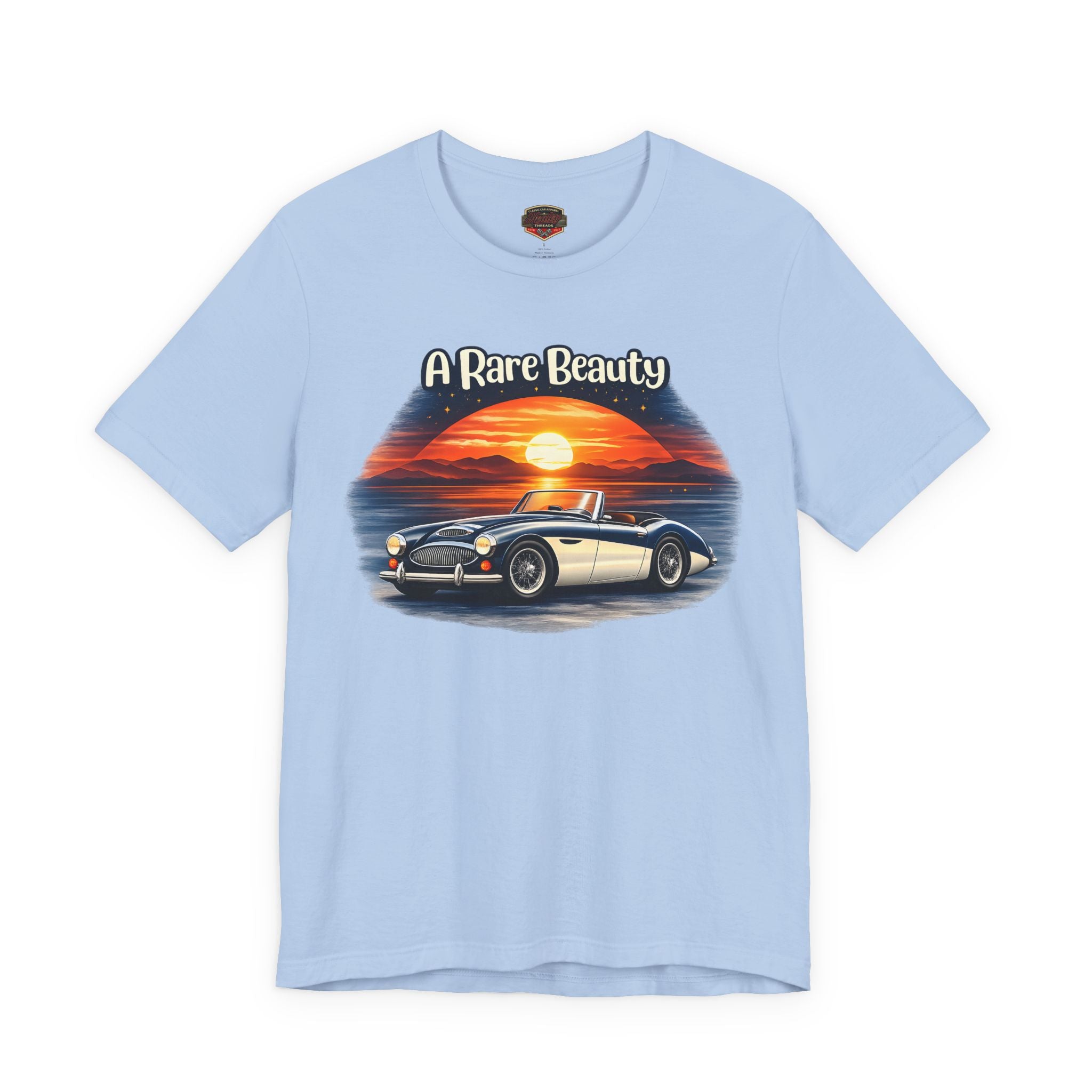 Light blue t-shirt with a Healey graphic of a car and sunset, labeled 'A Rare Beauty', on a white background.