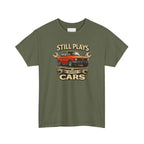 Military green t-shirt with a graphic of a red car and text 'Still Plays with Cars' on a white background