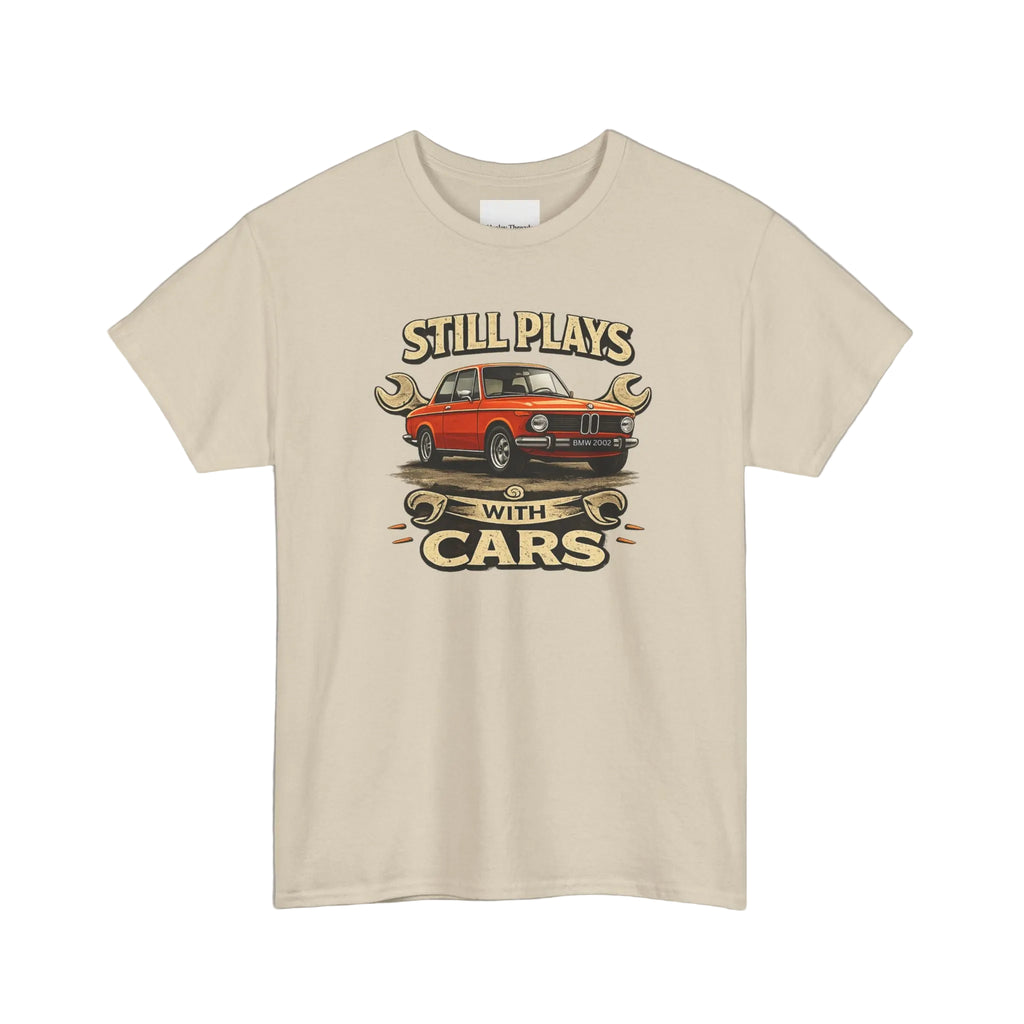 Beige t-shirt with a graphic of a red car and text 'Still Plays with Cars' on a white background