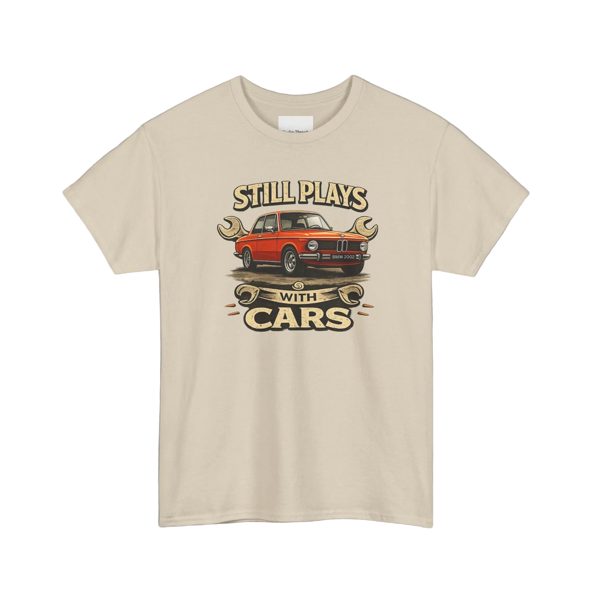 Beige t-shirt with a graphic of a red car and text 'Still Plays with Cars' on a white background