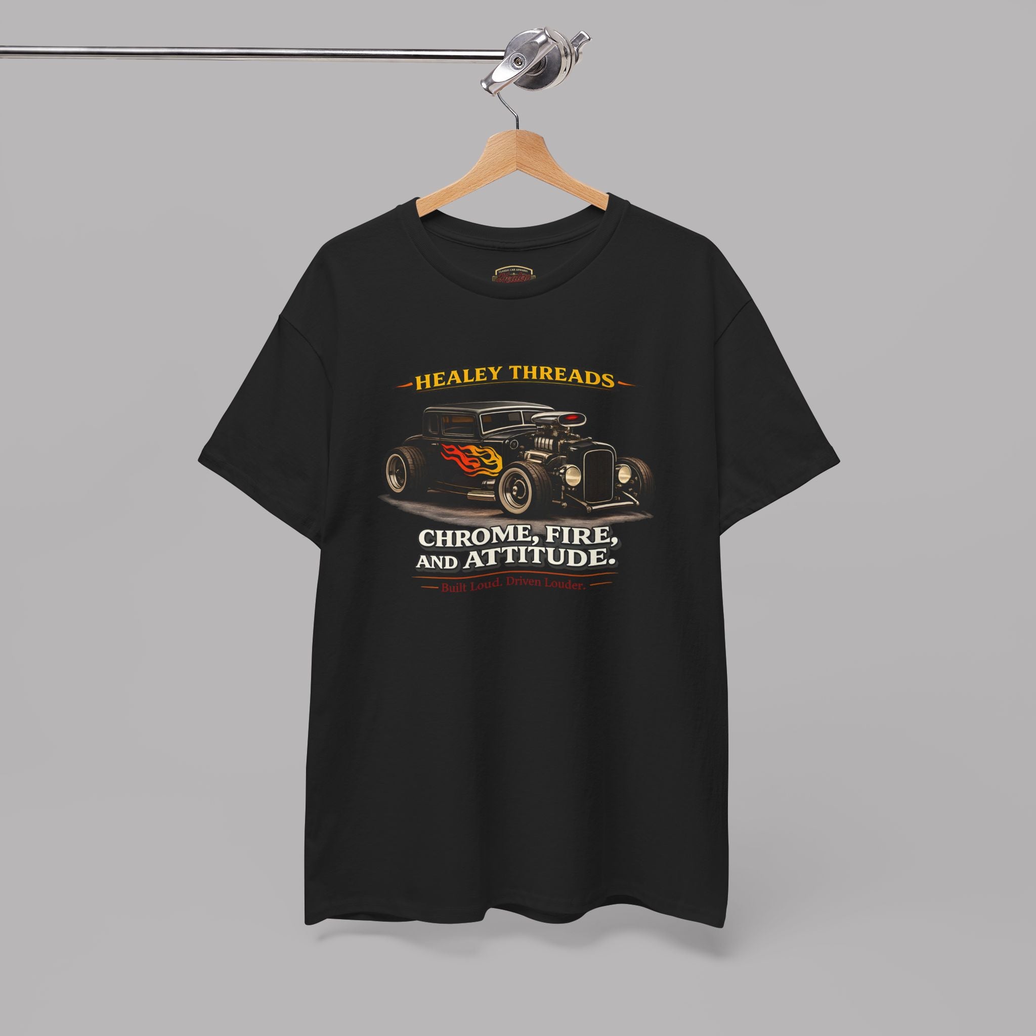 Black t-shirt with a hot rod graphic design and text on a hanger against a gray background
