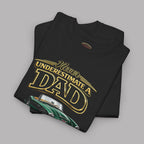Folded black t-shirt with yellow text 'Never Underestimate a Dad' on a gray background