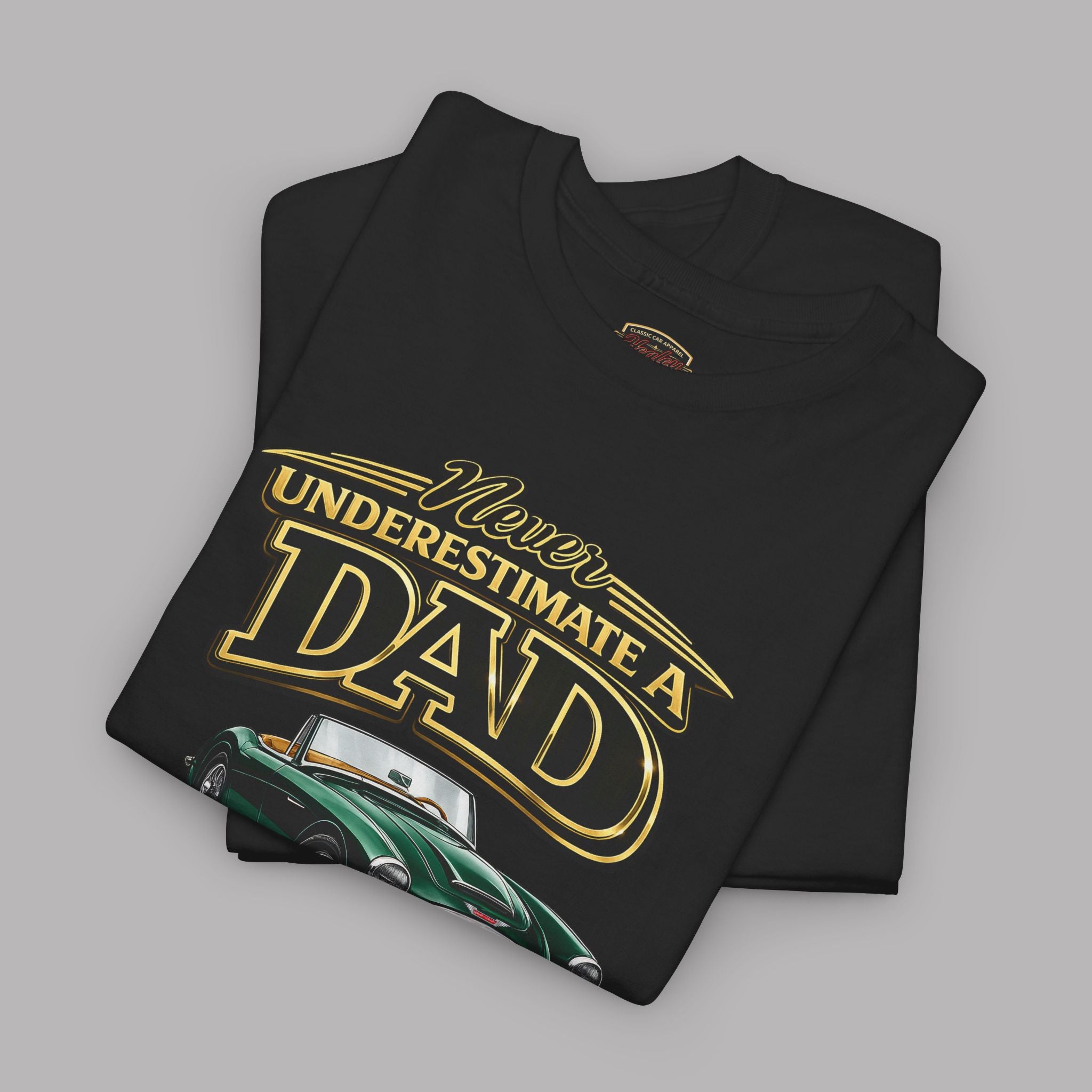 Folded black t-shirt with yellow text 'Never Underestimate a Dad' on a gray background