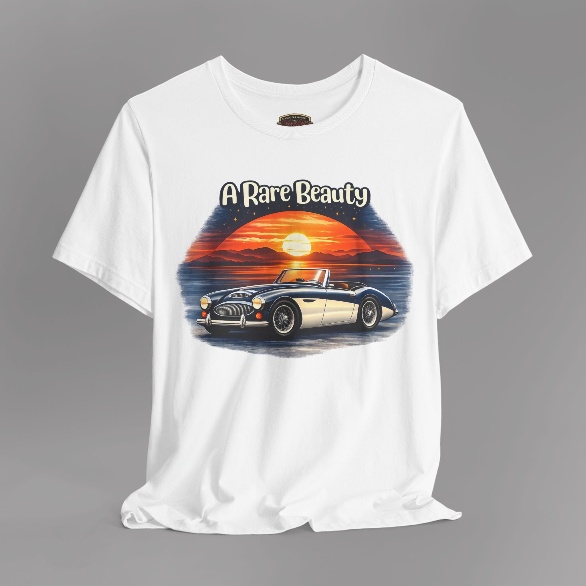 White t-shirt with a graphic of a Healey classic car and sunset design on a gray background