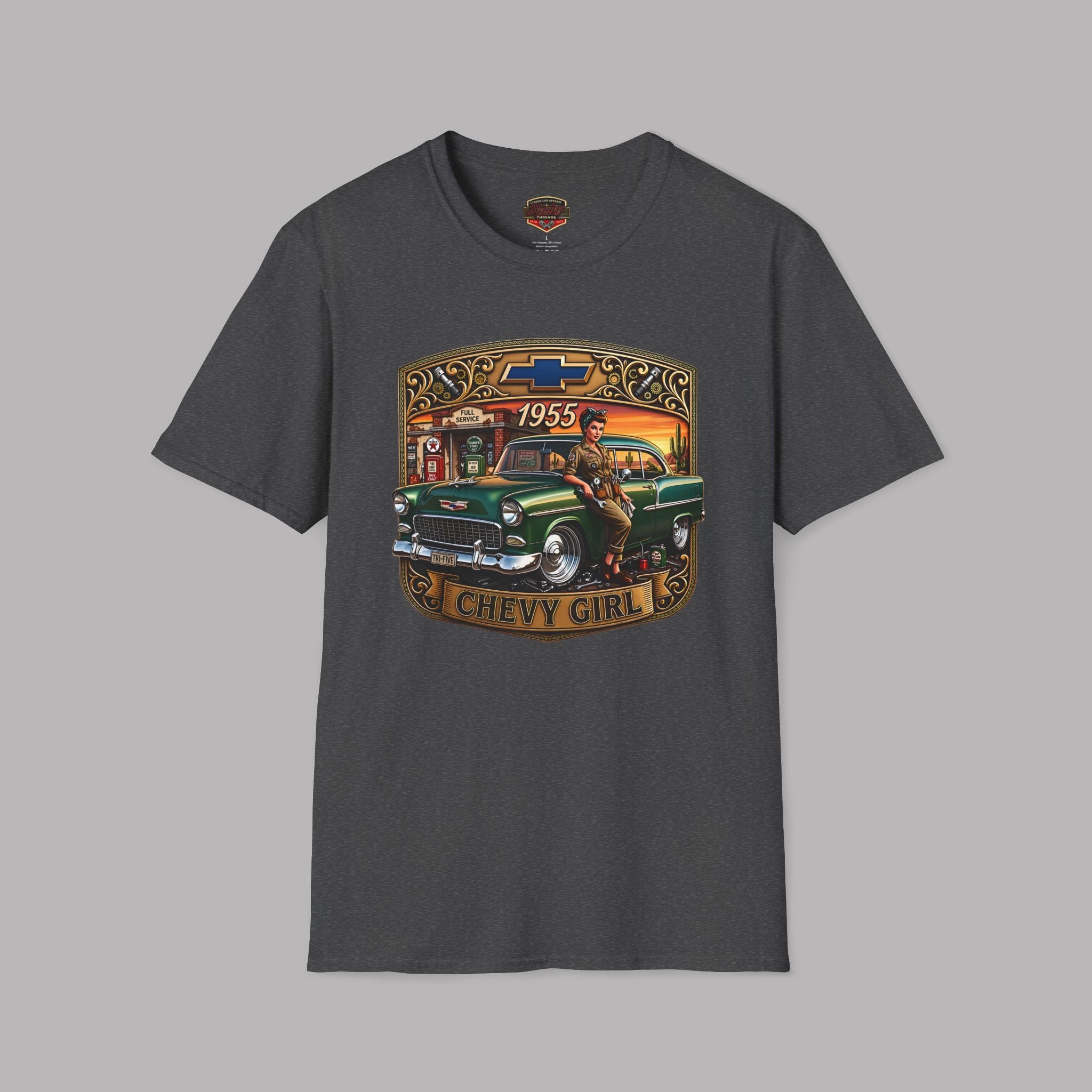 A dark gray crewneck t-shirt featuring a vintage-style graphic print of a green classic car with a gold sign that reads 'CHEVY GIRL' and '1955'. The Chevrolet bowtie logo is visible on the graphic and inside the collar label.