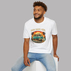 Man wearing a white t-shirt with a graphic retro van design sitting on a white stool against a gray background