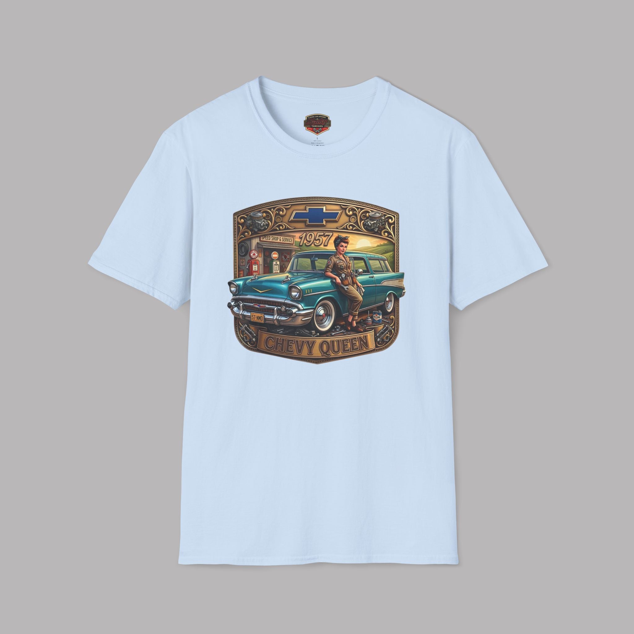 A light blue short-sleeve crewneck t-shirt featuring a large graphic print on the front. The graphic depicts a vintage teal station wagon with a cowboy sitting on it, framed by a gold-colored border with the text 'CHEVY QUEEN' and a Chevrolet bowtie logo at the top, set against a solid gray background.