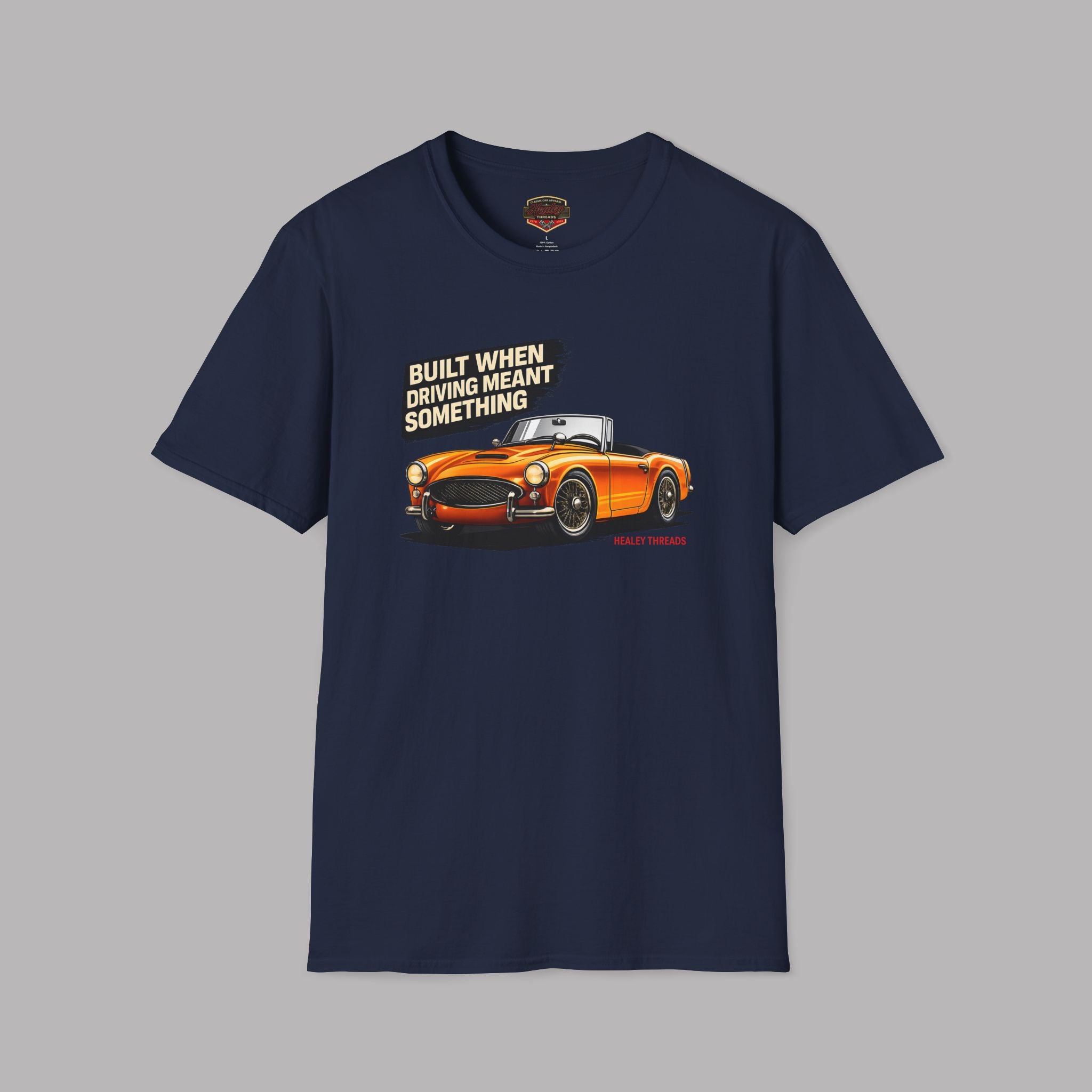 Navy blue t-shirt with orange car graphic and text on a gray background