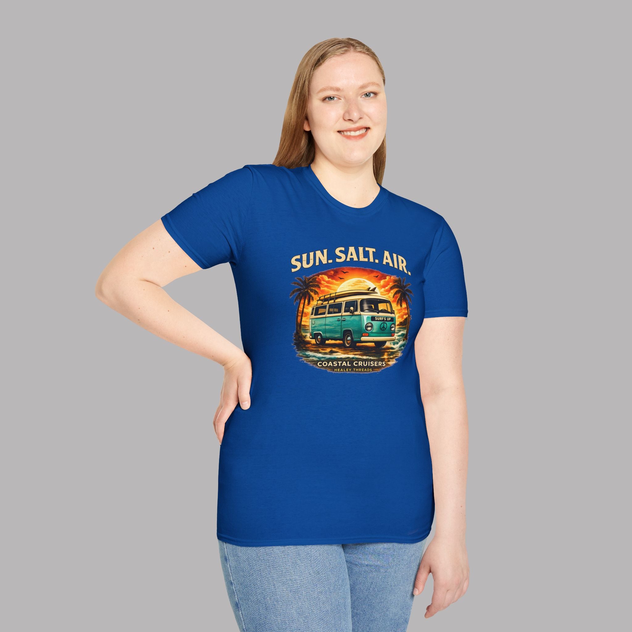 Woman wearing a blue t-shirt with a graphic retro van design and text on a gray background