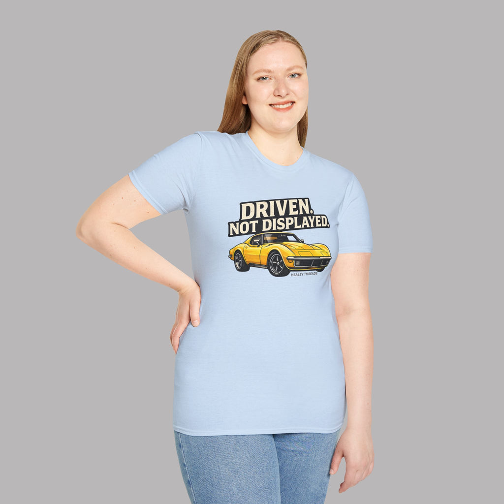 Woman wearing a light blue t-shirt with a yellow muscle car graphic and text on a gray background