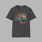 A dark heather short-sleeve crewneck t-shirt featuring a vintage-style graphic print of a teal 1957 Chevrolet station wagon with a woman sitting on it, framed by a gold and brown border with the text 'CHEVY QUEEN'.