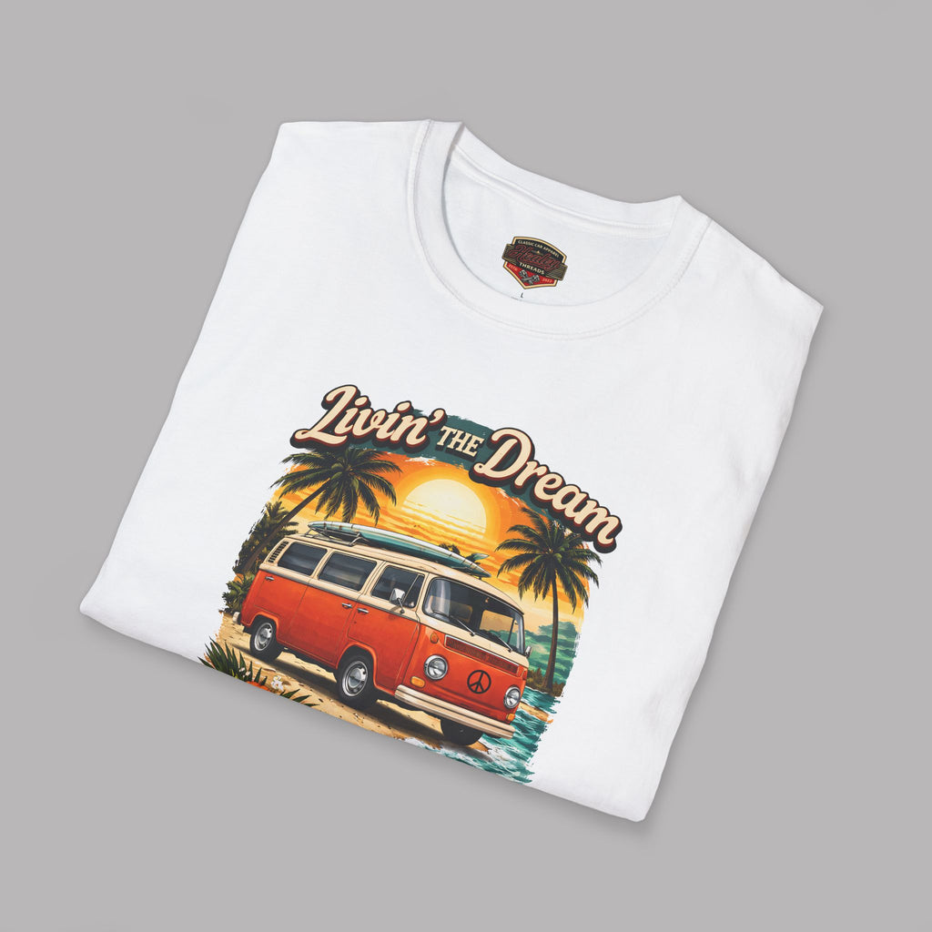 Folded white t-shirt with a graphic of a van and palm trees, featuring the text 'Livin' the Dream', on a gray background.