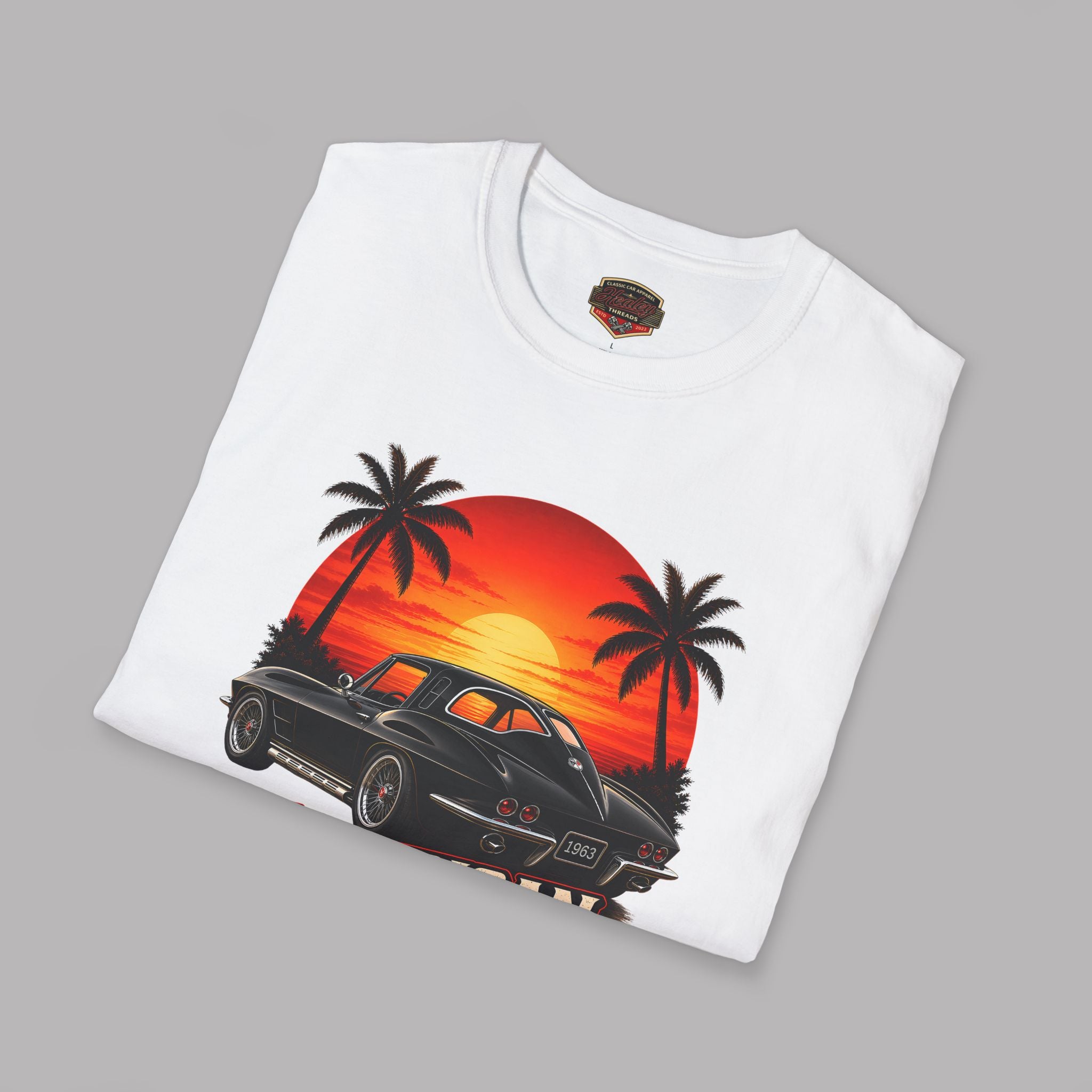 Folded white t-shirt with a car and sunset design on a gray background