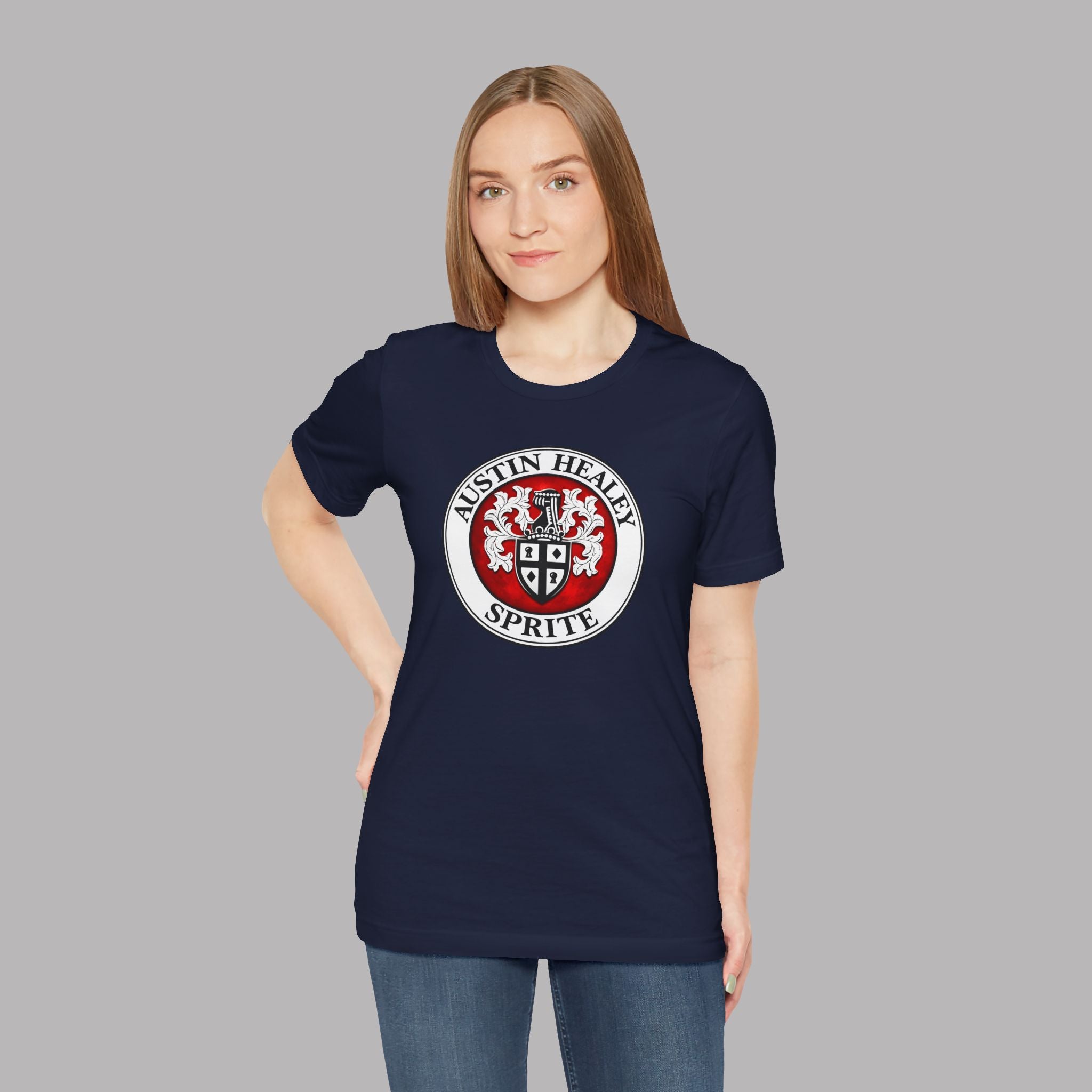Woman wearing a navy blue t-shirt with a red and white Healey Sprite logo on a gray background