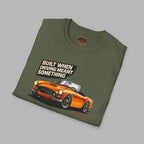 Folded military green t-shirt with a car graphic and text on a gray background
