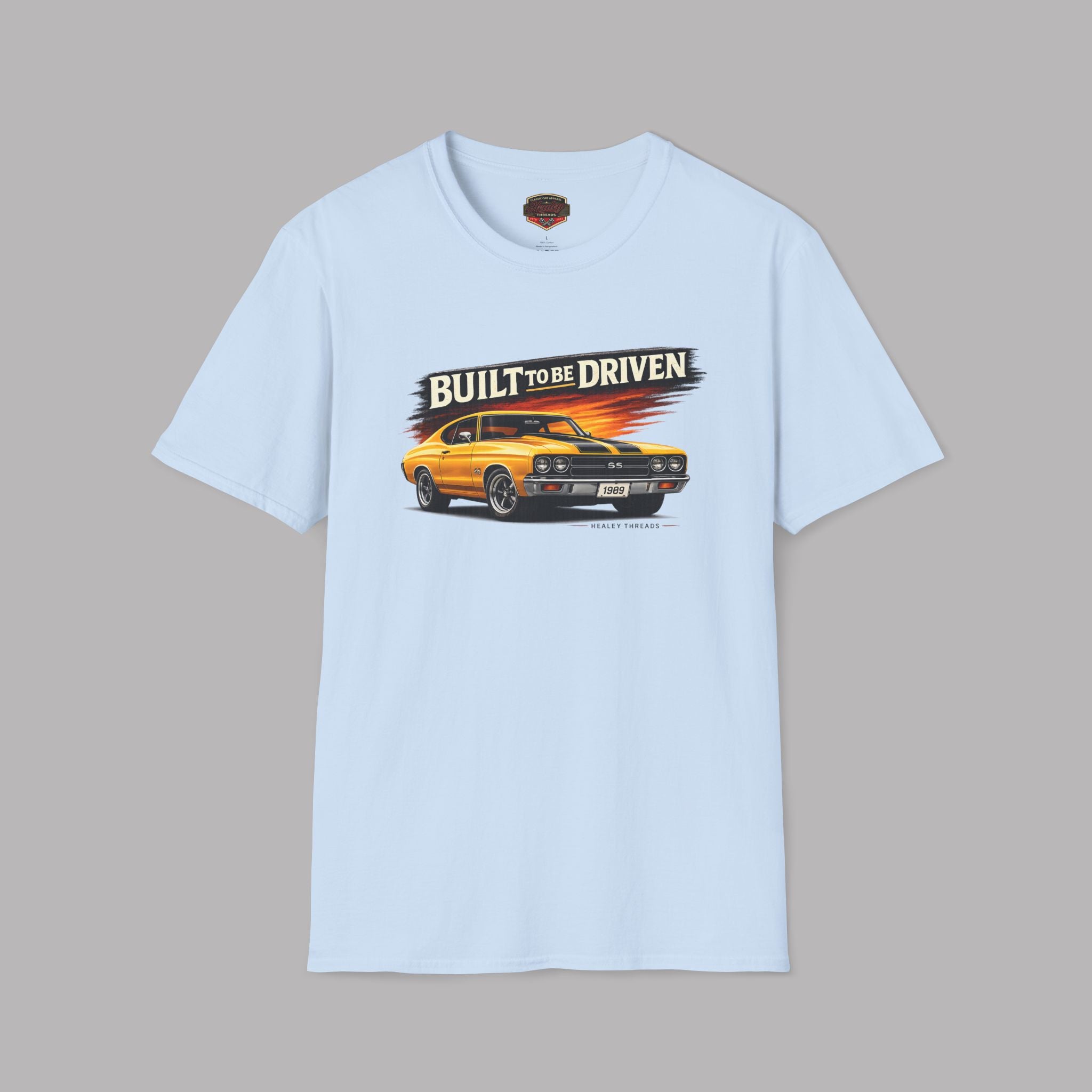 Light blue t-shirt with a graphic of a yellow car and 'Built to be Driven' text on a gray background