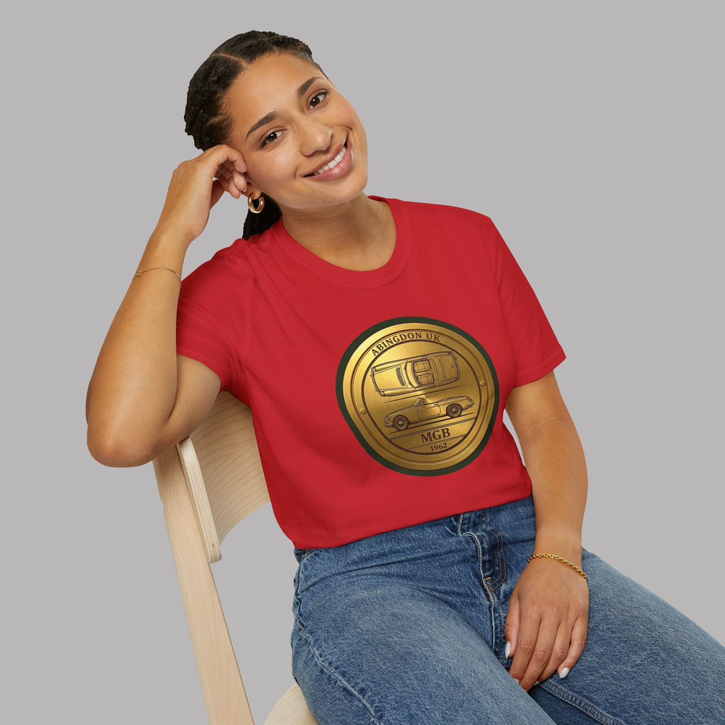 Woman wearing a red t-shirt with a gold classic car emblem sitting on a chair against a gray background