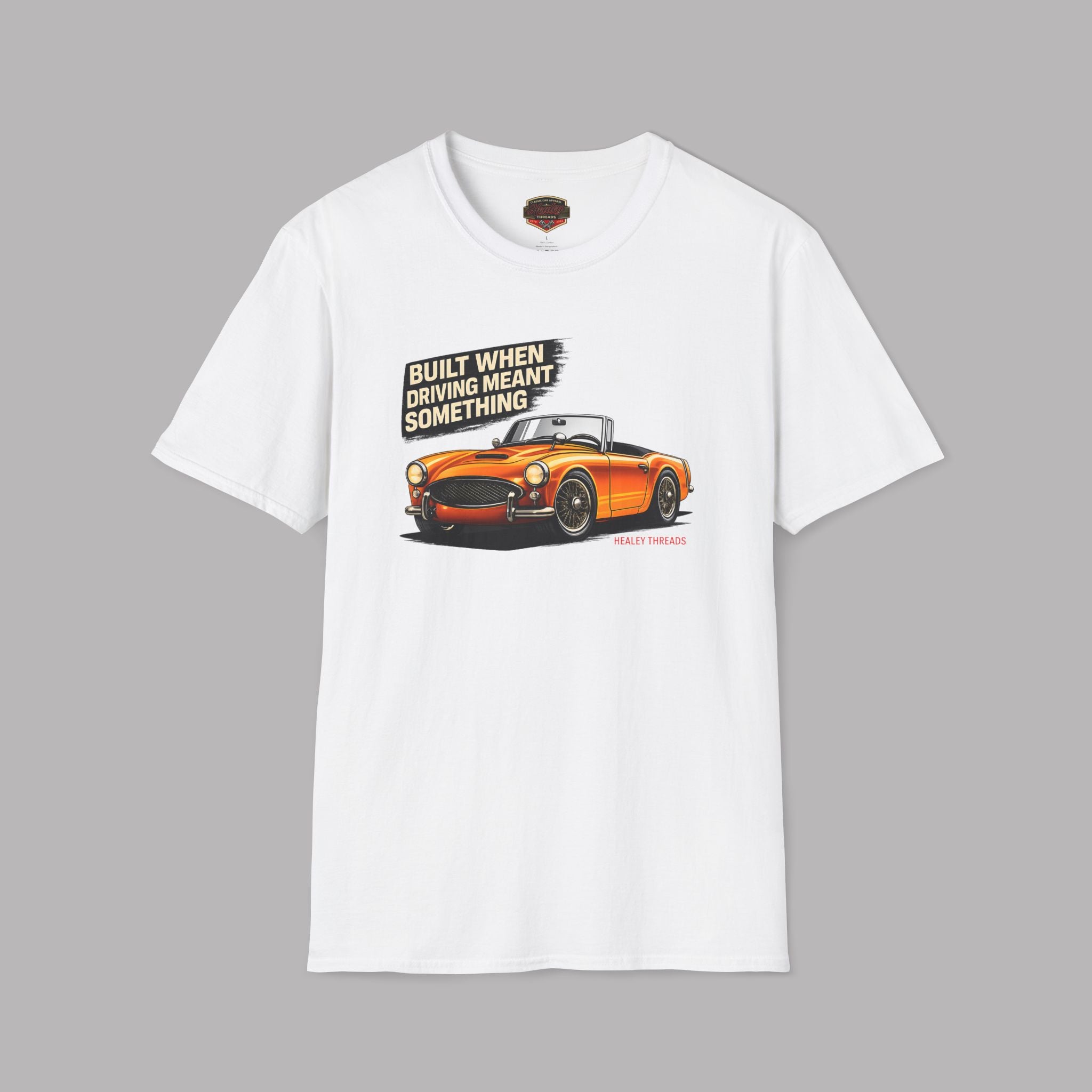 White t-shirt with an orange car graphic and text on a gray background