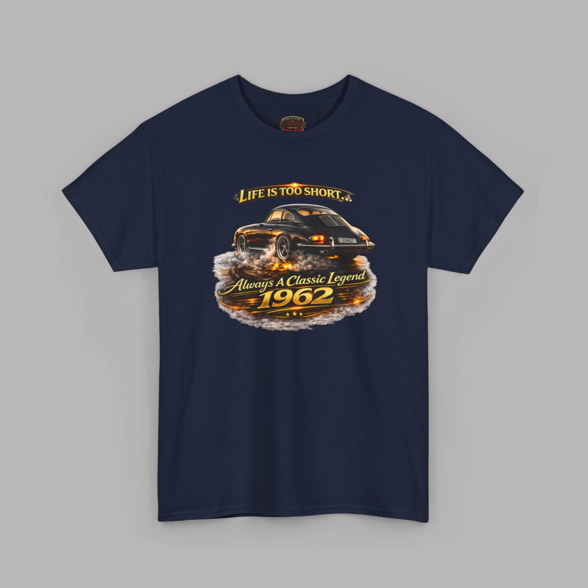 A navy blue short-sleeve t-shirt with a graphic print of a classic car and the text 'Life is too short to 1962 Always be a Classic Legend' on a solid gray background.