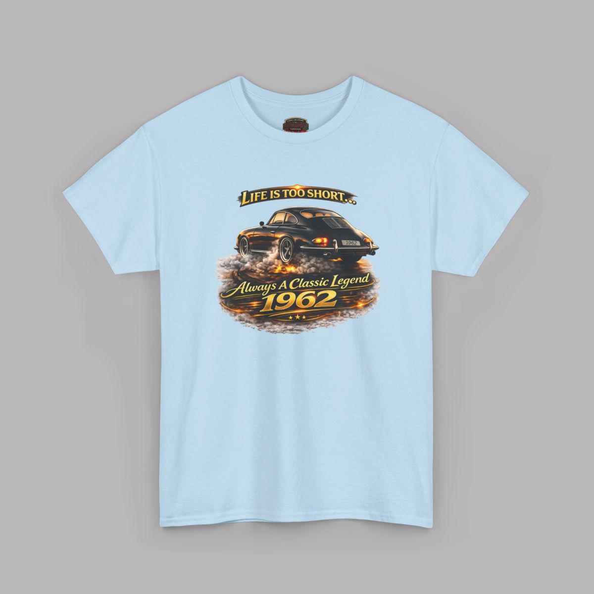 A light blue short-sleeve crewneck t-shirt featuring a vintage graphic of a black sports car with flames and the text 'Life is too short. Always a Classic Legend 1962'.