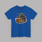 A royal blue short-sleeve t-shirt with a graphic print of a black sports car on a drag-racing track, surrounded by flames and smoke. The text 'LIFE IS TOO SHORT.