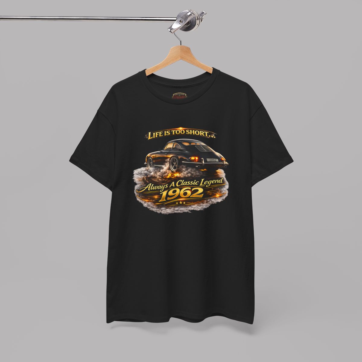 Hanging black short-sleeve t-shirt featuring a graphic print of a classic car with flames and the text 'Life is too short to be ordinary. Always be a classic legend 1962'.