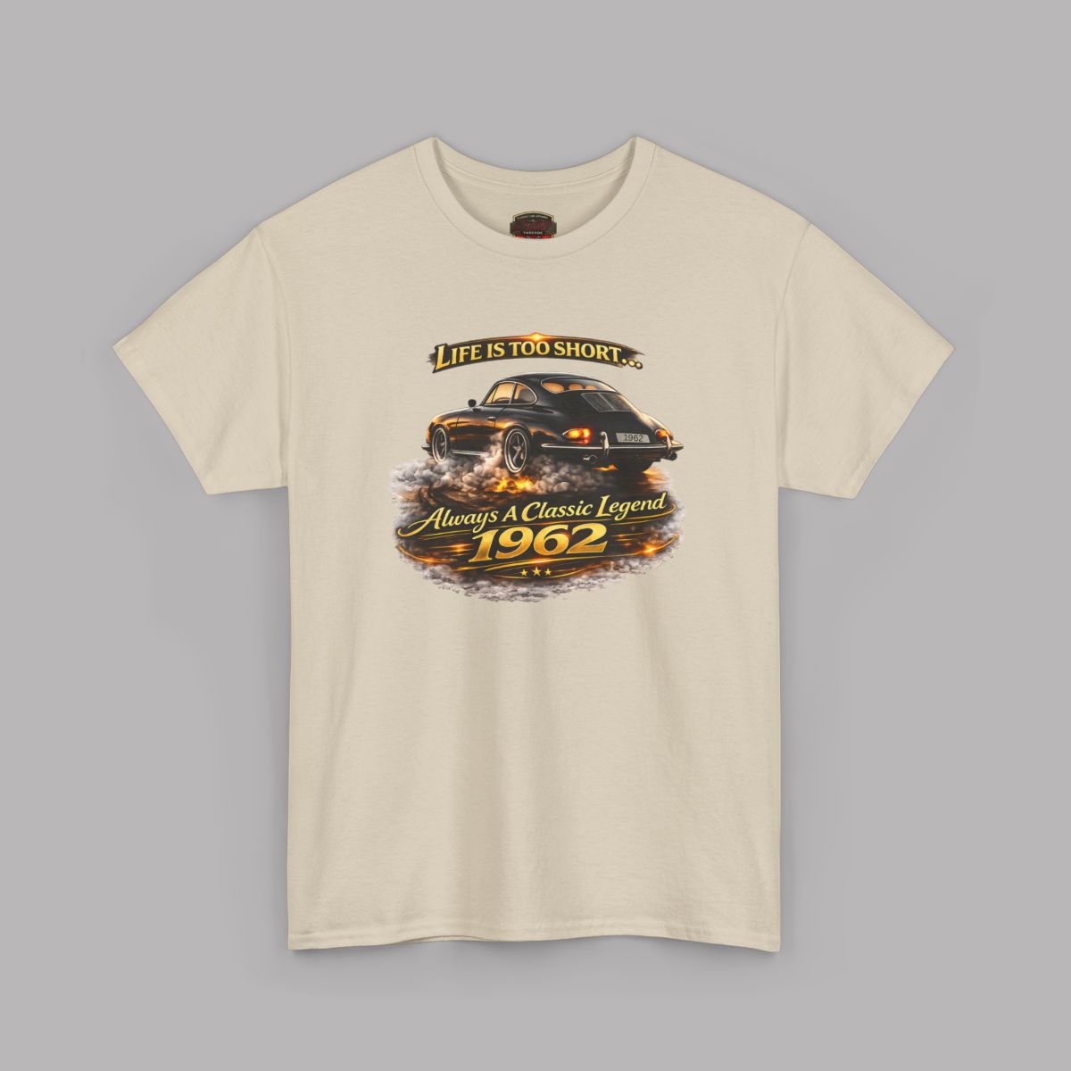 Sand short-sleeve crewneck t-shirt featuring a graphic print of a classic car with flames and the text 'Life is too short to be ordinary. Always be a classic legend 1962'.
