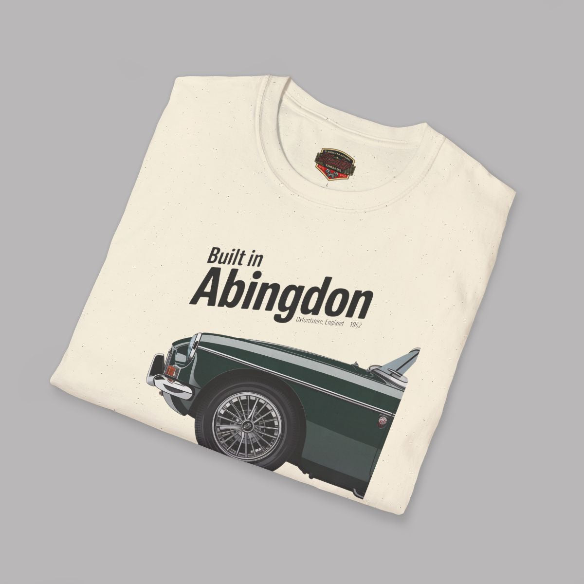 Folded natural t-shirt with a graphic of a MGB car and text 'Built in Abingdon' on a gray background