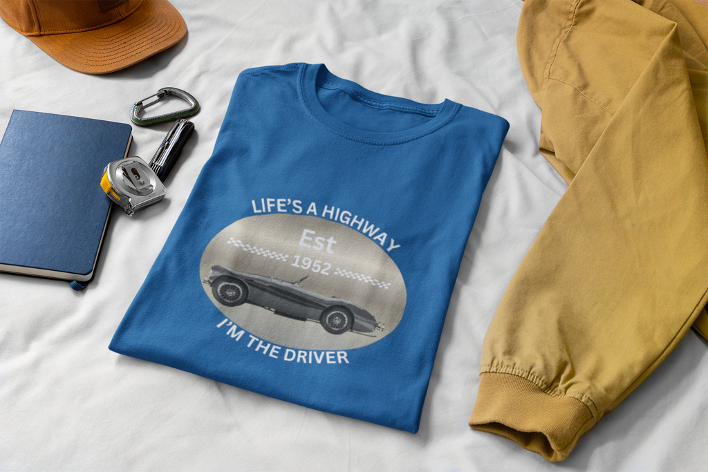 Royal blue t-shirt with graphic design on a white surface with accessories.