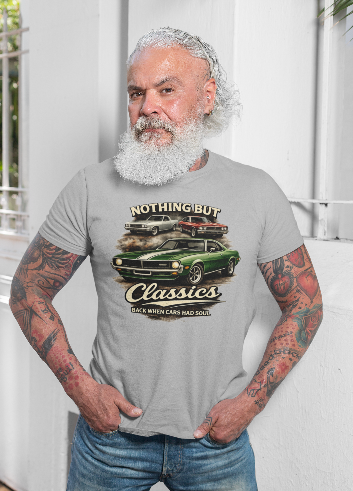 Man wearing a t-shirt with a graphic design of classic cars and text.