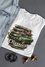 White t-shirt with car graphic and text, denim jacket, sunglasses, and bracelets on a gray background