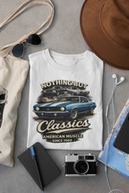 T-shirt with car graphic and text on a gray surface with accessories