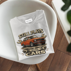 Folded t-shirt with car graphic and text on a white chair