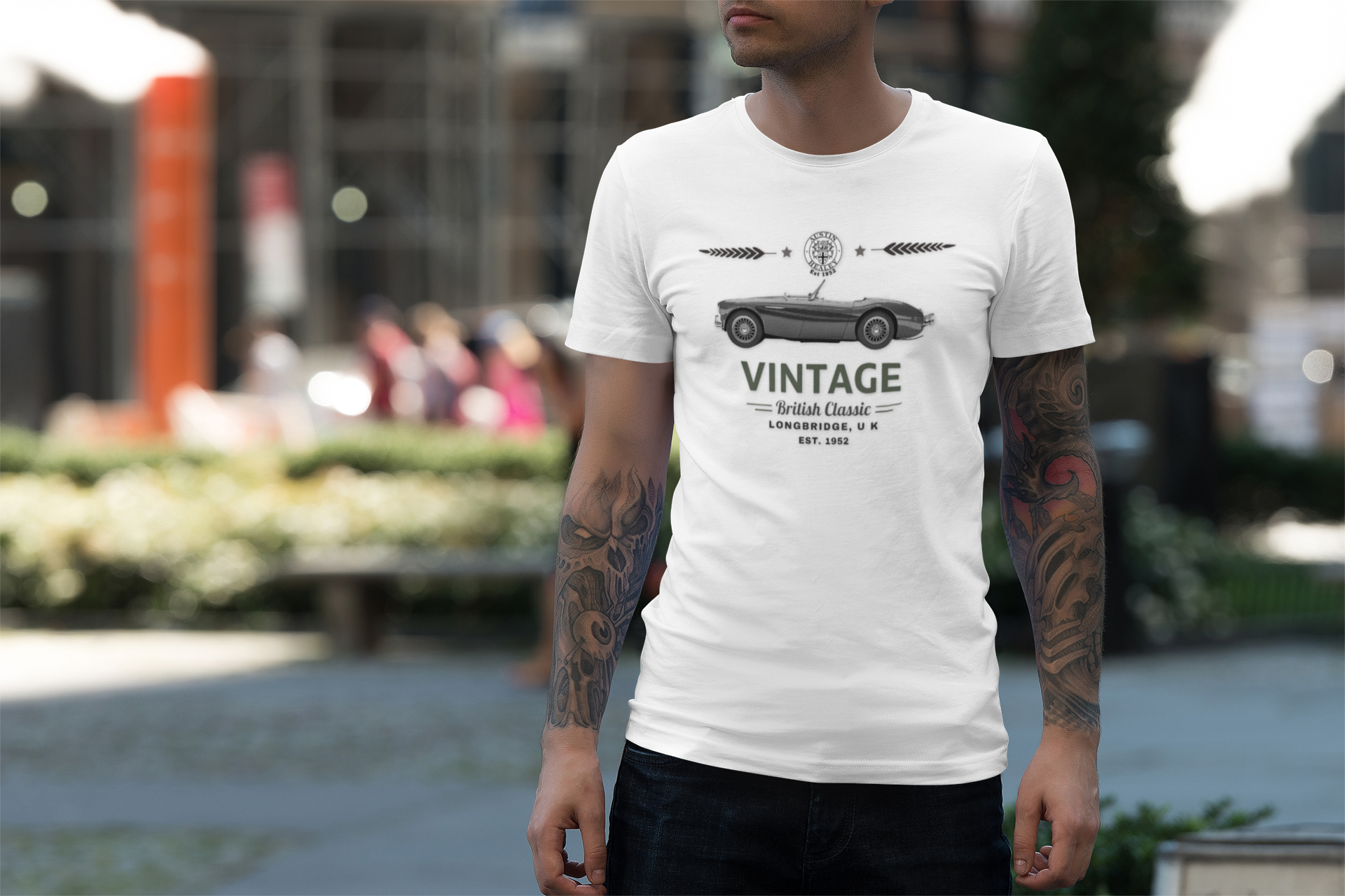 Man wearing a white t-shirt with a vintage car design outdoors.