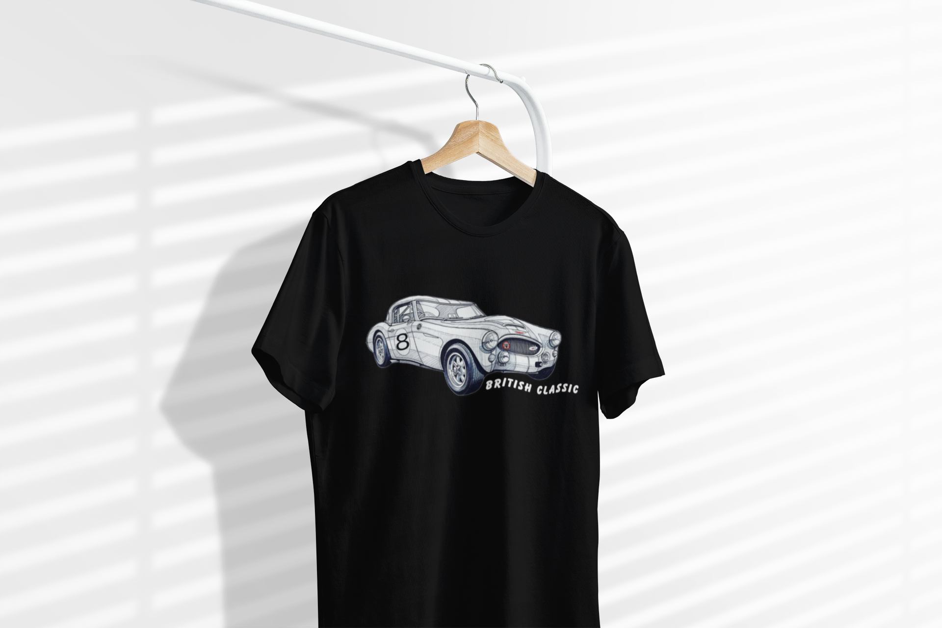 Black t-shirt with a car graphic on a hanger against a white background