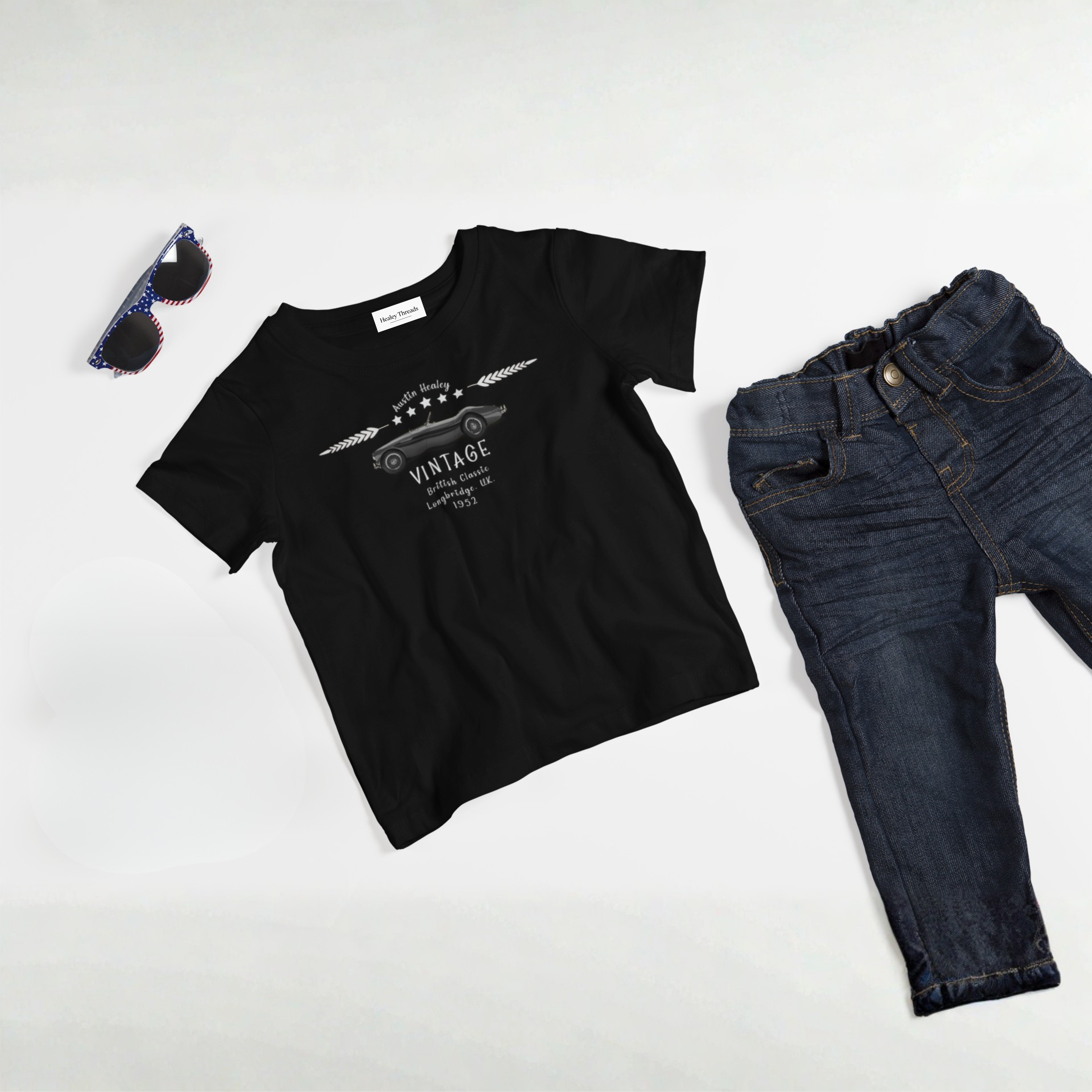 Black t-shirt with graphic design, dark jeans, and sunglasses on a white background