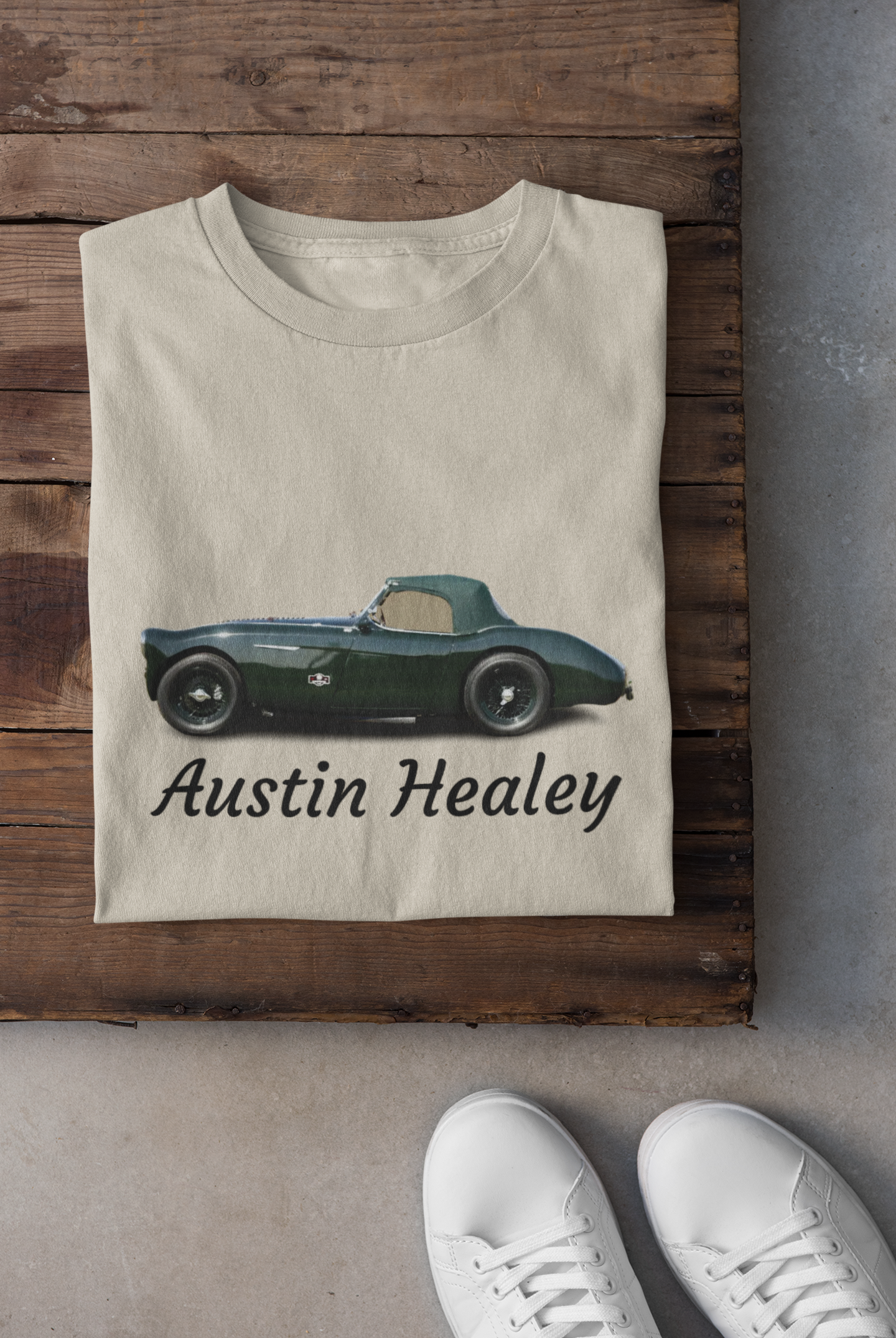Beige t-shirt with Austin Healey car design on a wooden surface