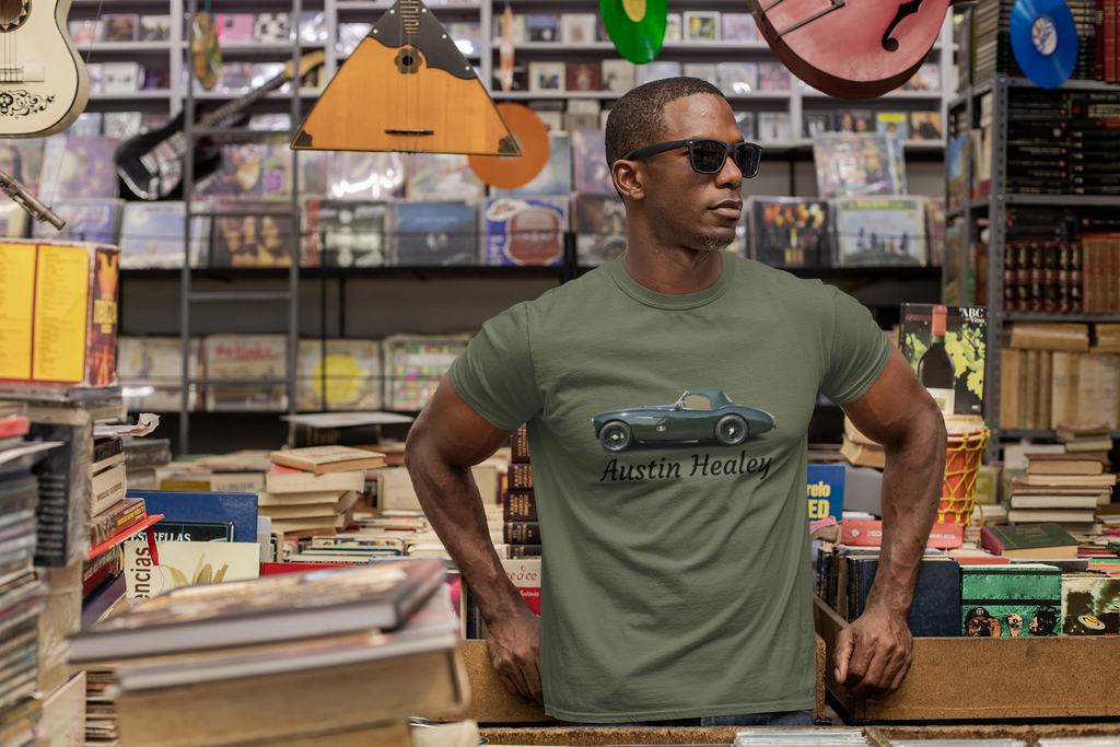 Man wearing a military green t-shirt with a car design in a store with books and musical instruments.