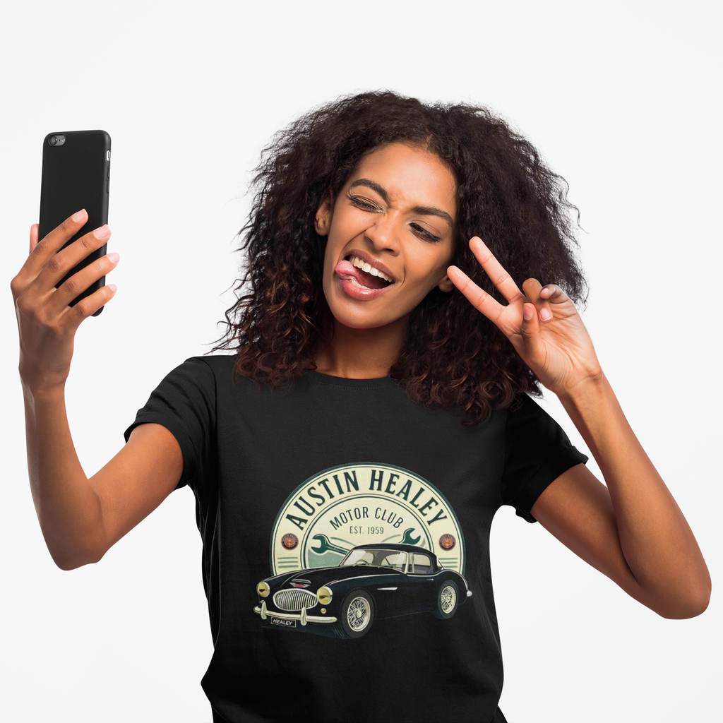 Woman wearing a black t-shirt with Austin Healey logo, taking a selfie on a white background