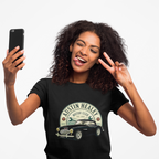 Woman wearing a black t-shirt with Austin Healey logo, taking a selfie on a white background