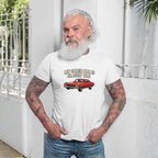 Man wearing a white t-shirt with a graphic and text, standing against a light-colored wall.