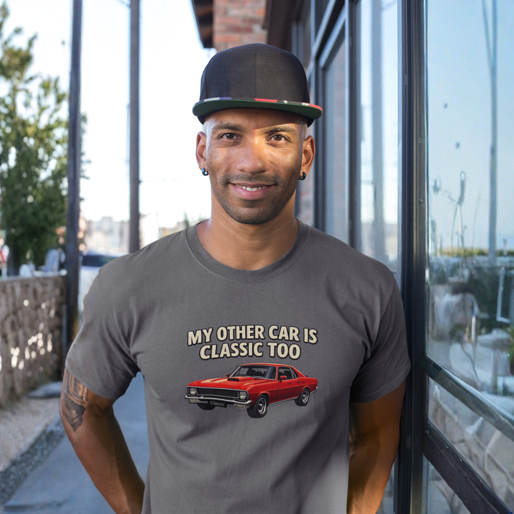 Man wearing a gray t-shirt with a graphic and text, standing outdoors.