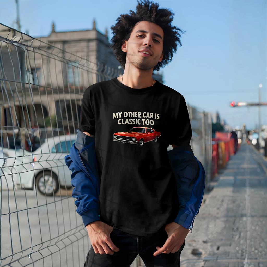Man wearing a black t-shirt with a graphic and text, standing outdoors.