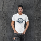 Man wearing a white t-shirt with a logo against a textured gray wall