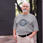 Man wearing a gray t-shirt with 'Heritage Classic Collection' text, standing outdoors.