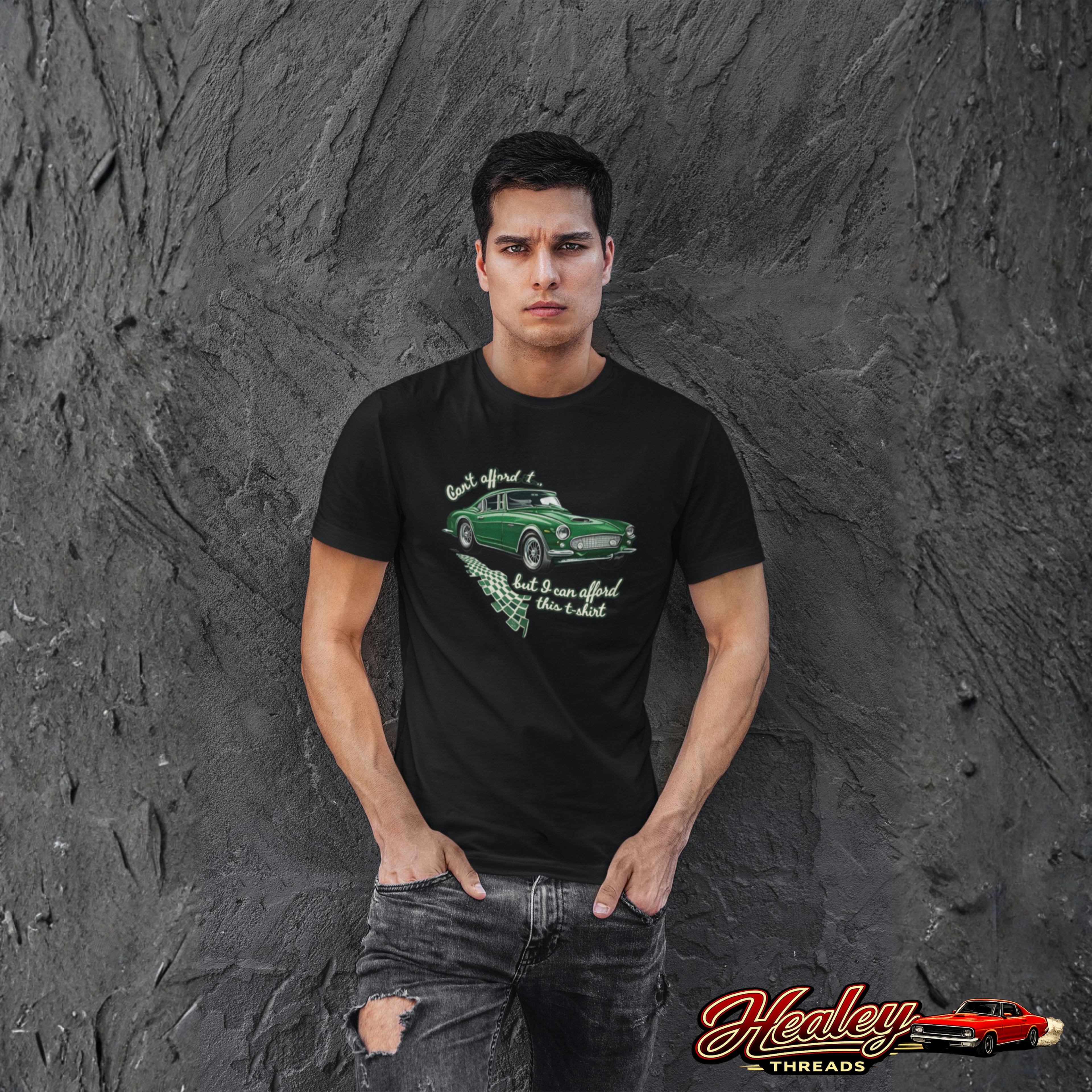Man wearing a black t-shirt with a green car graphic against a textured gray wall.