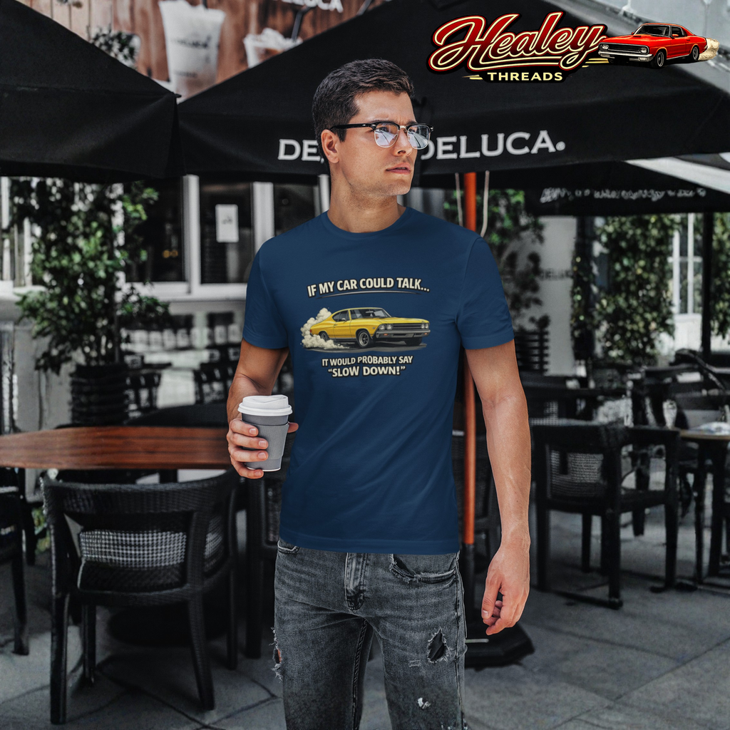 Man wearing a blue t-shirt with a graphic design, holding a coffee cup, standing in an outdoor setting.